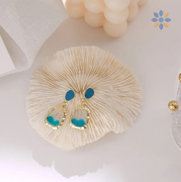 Aretes colgantes dorados con detalle turquesa elegante