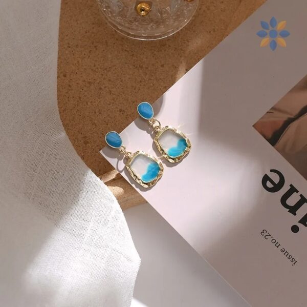 Aretes colgantes dorados con detalle turquesa elegante