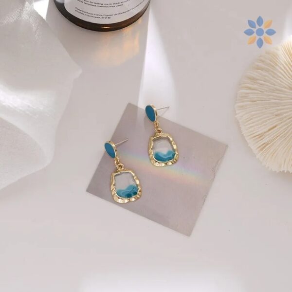 Aretes colgantes dorados con detalle turquesa elegante